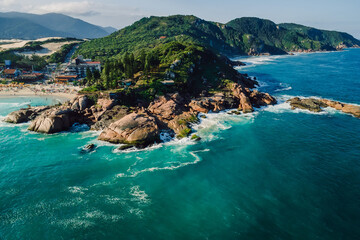 Scenic landscape with Joaquina beach, rocks, mountains and ocean with waves in Brazil. Aerial view