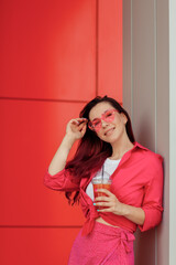 Young beautiful woman with pink hair on a bright background with lemonade