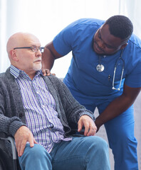 Fototapeta premium Professional doctor helps an elderly man with chronic diseases. Therapist and patient in home interior. Health care and medicine concept.