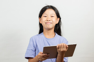 笑顔でタブレットを操作している小学生の女の子の様子 - obrazy, fototapety, plakaty