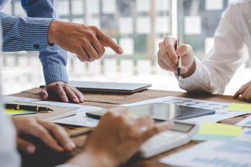 Young colleagues discussing business and price chart analyzes business people on the table great in modern coworking office teamwork concept.