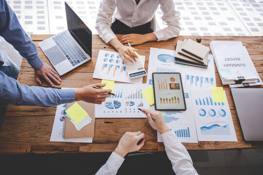 Young colleagues discussing business and price chart analyzes business people on the table great in modern coworking office teamwork concept.