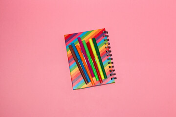 colorful notebook with colorful markers on it, pink background, back to school, creative art design, colorful minimalism