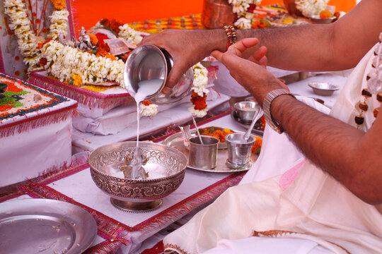 Puja in a Hindu temple : bathing of a statue of goddess Durga with milk