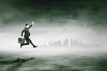 Businessman run fast with misty city background