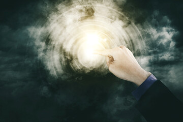 Fototapeta na wymiar Businessman touching a bright button in cloudy sky