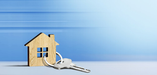Wooden model of house and key on a blue background