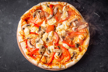 hot delicious traditional italian pizza on a dark stone background