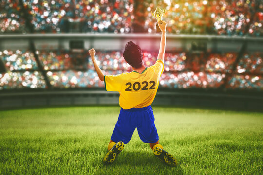 Male Soccer Player Lifting A Trophy In The Stadium