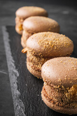 colored macaroons on a dark stone background