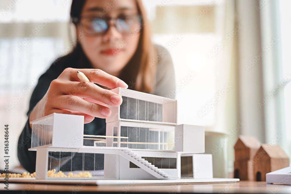 Poster undergraduate architecture students work on models of the modern box house. holding the part of the 