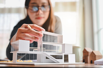 Undergraduate architecture students work on models of the modern box house. Holding the part of the...
