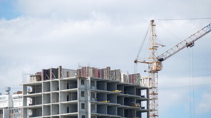 Fototapeta na wymiar Building house with a construction crane. Construction of a multi-storey building.