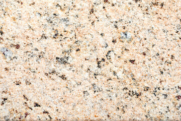 The texture of natural granite stone. The background of pinkish-beige stone interspersed with yellow, brown, gray and black tones. Copy Space