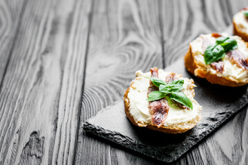 sandwich with anchovy fillet on a tray for serving on a black wooden rustic background
