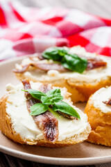 sandwich with anchovy fillet on a tray for serving on a wooden rustic background