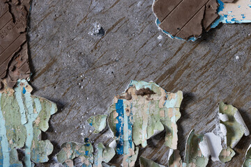 Peeling paint on the wall. Old concrete wall with cracked flaking paint. Weathered rough painted surface with patterns of cracks and peeling. Grunge texture for background and design. High resolution.