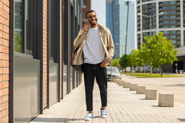 Fototapeta premium Black man talking on a cell phone walking down the street.