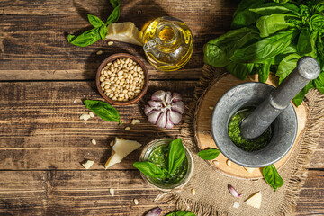 Homemade Italian basil pesto sauce in a vintage mortar with pestle