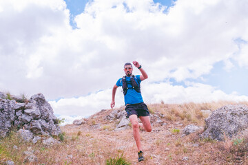 active man training on mountain with trail running and running fast