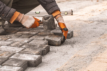 Laying paving slabs close-up. Road surface, construction. Sidewalk repair. Worker laying stone...
