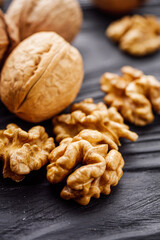 dried walnuts on a black rustic wooden background