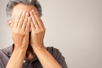 Man covering his face with his hands