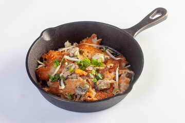 Hot pan of crispy fried oyster omelette served with bean sprout and spicy sauce.
