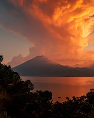 Vertical shot of the Lake Atitlan in the background of mountains in the sunset.