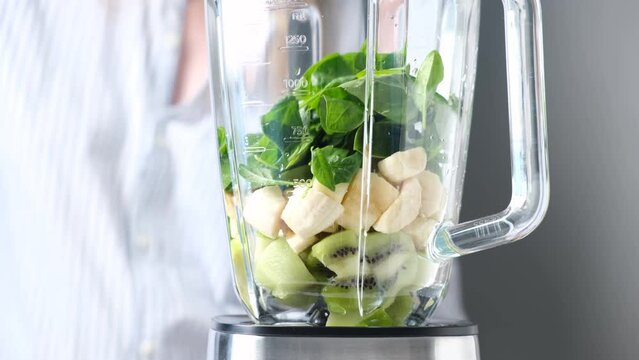 Making smoothie in blender, add ingredients in blender cup. Cooking process of healthy vegan green smoothie