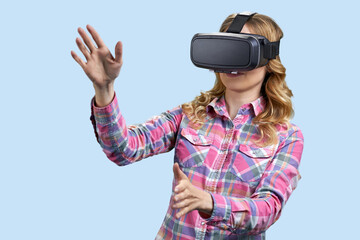 Excited young woman using virtual reality glasses on color background. Technology, new generation and progress concept.
