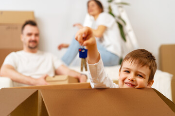 Obraz premium Portrait of happy family with cardboard boxes in new house at moving day