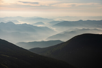 Morning fog in spring mountains. Beautiful sunrise on background. Landscape photography