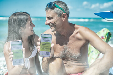 Happy family on the beach with covid green pass. Man and 10 years old daughter ready to go on a...