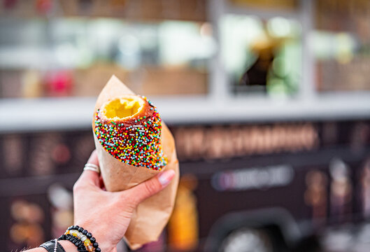 Woman holds in hand Trdlo or Trdelnik, Traditional tasty baked Czech Republic. street food