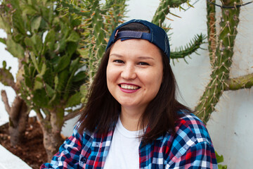 yound pretty american woman siting smiling among cactuses, lifestyle people concept