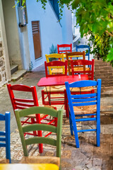 Fototapeta na wymiar Colourful wooden chairs outside an island restaurant in summer, holiday concept