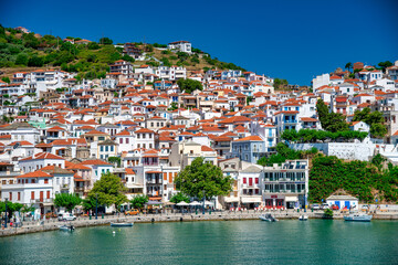 Fototapeta na wymiar Skopelos, Greece - July 1, 2022: Homes of Skopelos Island along the city port