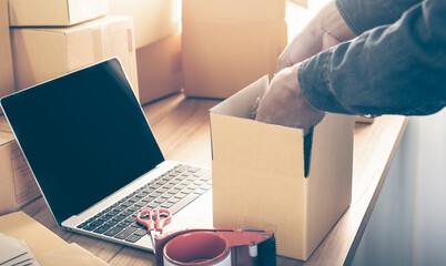 Young entrepreneur business owner work at home, small business startup receive order client and take note working with report and pack the product on purchase delivery online to sending destination.