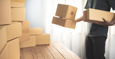 Small business owner packing in the cardbox at workplace. Cropped shot of man preparing a parcel for delivery at online selling business office. Ecommerce drop shipping shipment service concept.