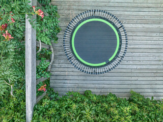 mini trampoline for fitness exercising and rebounding in a backyard patio, top aerial view