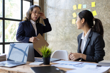 Senior executives discussing with young female employees in the office meeting room.