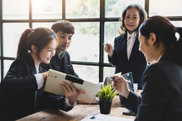 Business meeting. The senior manager talks to employees in the conference room and discuss company project development strategies during the meeting.