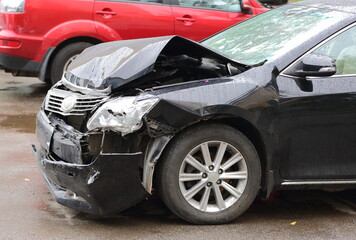 A smashed black car after an accident