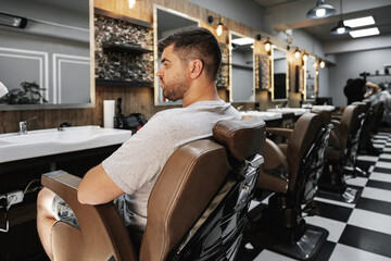 Young man client sitting in a barber shop