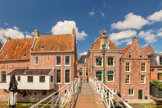 Summer view of Dutch medieval houses with hanging kitches at the Damsterdiep canal in Appingedam, Groningen, The Netherlands