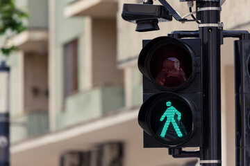 Pedestrian semaphore with speaker showing green light - 516373629