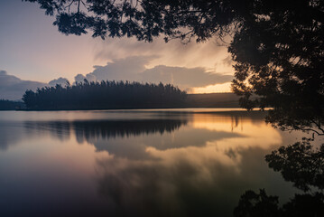 Fototapeta na wymiar Serene view of a lake during sundown captured using long exposure with perfect reflection