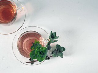 Fragrant mint tea on a light background. A cup of tea, a bunch of fresh mint. Herbal tea...