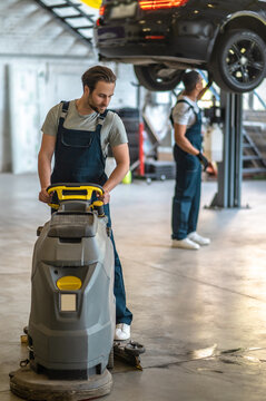 Technicians Working In A Auto Repair Shop And Looking Busy